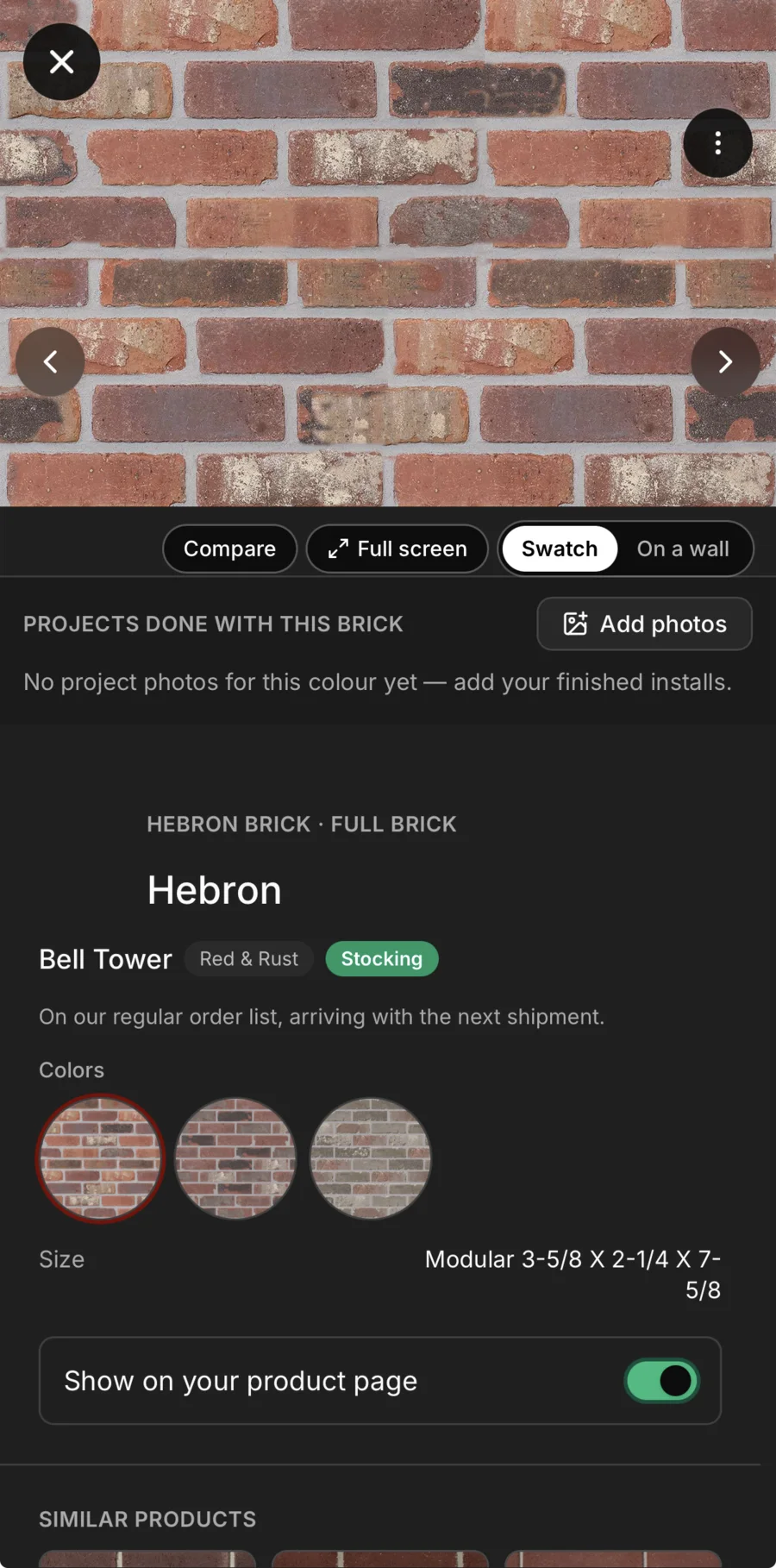 One product’s page in Daybook: Hebron full brick in Bell Tower — Red & Rust, Stocking, “On our regular order list, arriving with the next shipment” — a close-up swatch with Compare, Full screen and On a wall, its three colours, its modular size, a switch to show it on your product page, and a place for photos of projects done with this brick.